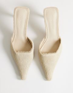 Model wearing Alfie real hair on leather pointed mid heeled mule court shoe in off white
