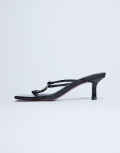 Model wearing Alice hardware square toe heeled mule in black