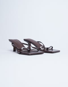Model wearing Alice hardware square toe heeled mule in chocolate