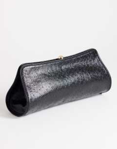 Model wearing Alice medium clutch bag in black ostrich