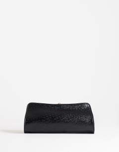 Model wearing Alice medium clutch bag in black ostrich
