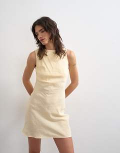 Model wearing Aline cupro backless mini dress in buttermilk