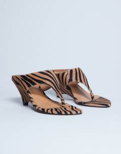 Model wearing Ally real leather toe thong wedge sandal in tiger pony