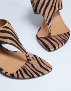 Model wearing Ally real leather toe thong wedge sandal in tiger pony