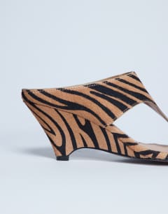 Model wearing Ally toe thong wedge sandal in tiger print hair on real leather
