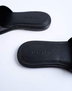 Model wearing Almina real leather square toe mules in black