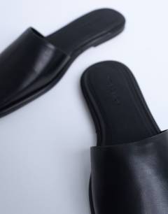 Model wearing Almina real leather square toe mules in black