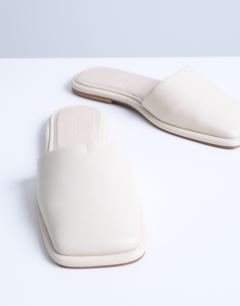 Model wearing Almina real leather square toe mules in off white