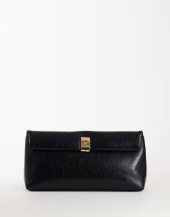 Model wearing Amber oversized fold over clutch bag with gold hardware in black