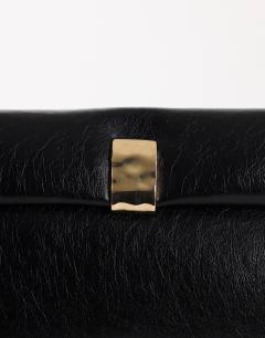 Model wearing Amber oversized fold over clutch bag with gold hardware in black