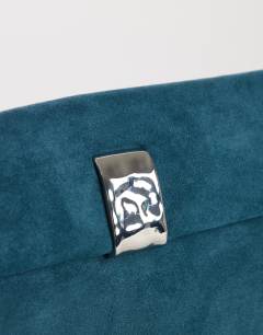 Model wearing Amber oversized suedette fold over clutch bag with hardware in teal