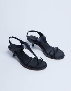 Model wearing Amber toe thong mid heel in black