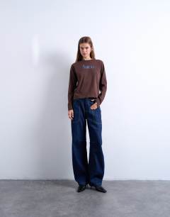 Model wearing Amico graphic boxy long sleeve tee in brown
