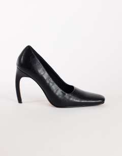 Model wearing Amos chiselled banana heel court shoe in black