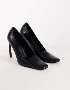 Model wearing Amos chiselled banana heel court shoe in black