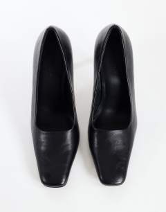 Model wearing Amos chiselled banana heel court shoe in black