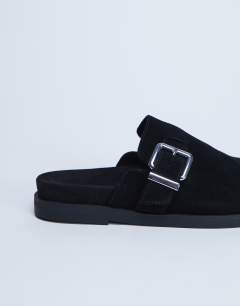 Model wearing Amy slip on mule with buckle in black