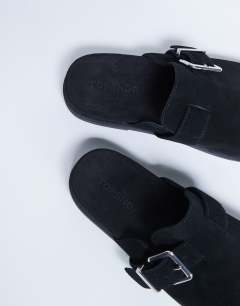 Model wearing Amy slip on mule with buckle in black
