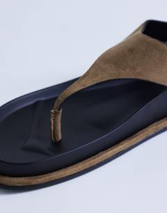 Model wearing Angela toe thing footbed flat sandal in taupe