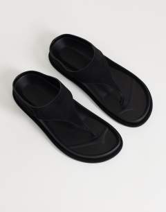 Model wearing Angela toe thong footbed flat sandal in black 