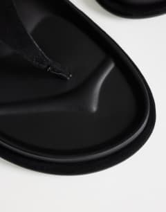 Model wearing Angela toe thong footbed flat sandal in black 