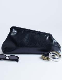 Model wearing Anna angular clutch bag in black