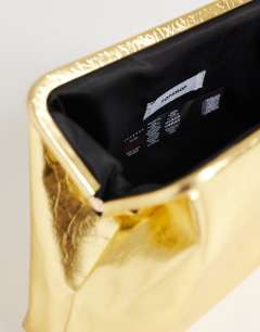 Model wearing Anna angular clutch bag in gold