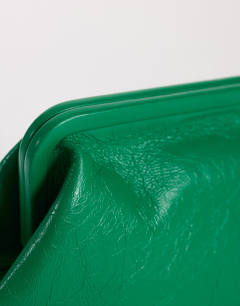Model wearing Anna angular clutch bag in green