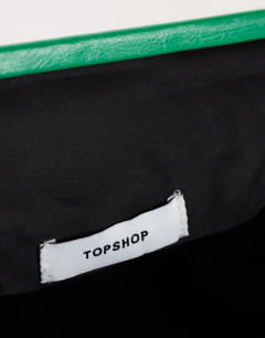 Model wearing Anna angular clutch bag in green
