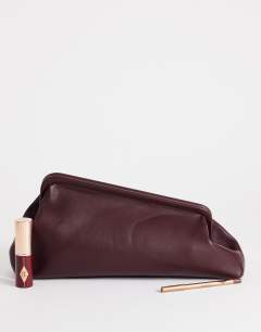 Model wearing Anna medium angular clutch bag in aubergine