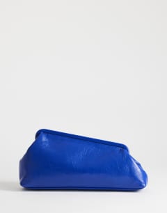 Model wearing Anna medium angular clutch bag in cobalt 