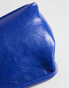 Model wearing Anna medium angular clutch bag in cobalt 