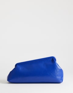 Model wearing Anna medium angular clutch bag in cobalt 
