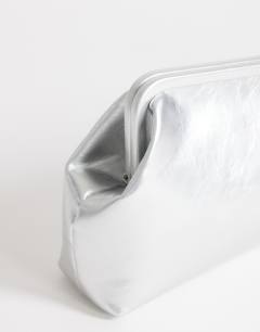 Model wearing Anna medium angular clutch bag in silver