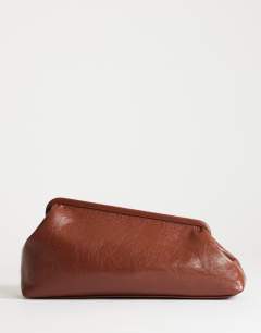 Model wearing Anna medium angular clutch bag in tan