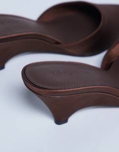 Model wearing Annie wedge closed toe shoe in chocolate
