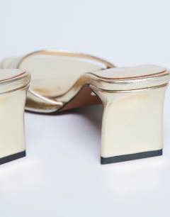 Model wearing Ari mule heeled sandal in gold