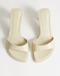 Model wearing Ari mule heeled sandal in off white