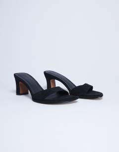 Model wearing Ari mule mid heeled sandal in black