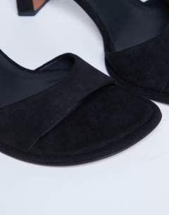 Model wearing Ari mule mid heeled sandal in black