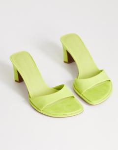 Model wearing Ari mule mid heeled sandal in lime