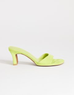 Model wearing Ari mule mid heeled sandal in lime
