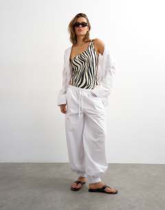 Model wearing Arlie asymmetric open back swimsuit in zebra