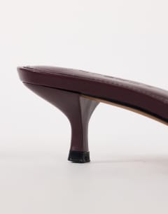 Model wearing Arthur rounded toe mid heel mule in aubergine