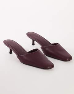 Model wearing Arthur rounded toe mid heel mule in aubergine