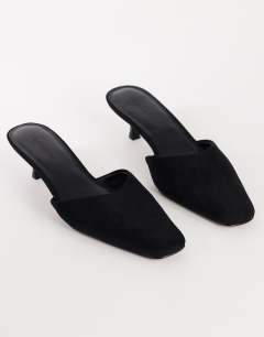 Model wearing Arthur rounded toe mid heel mule in black faux suede