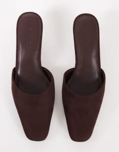 Model wearing Arthur rounded toe mid heel mule in chocolate faux suede