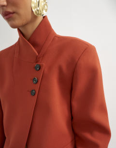 Model wearing Assymetric neck button detail blazer in rust