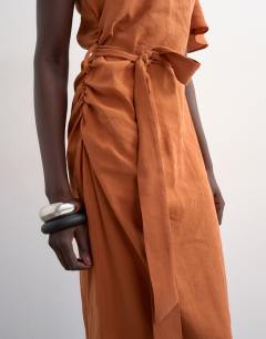 Model wearing Asym sleeve tie waist cupro maxi dress in burnt brown
