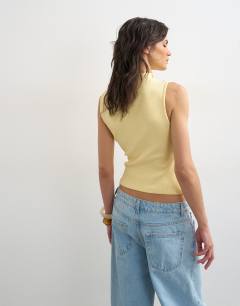 Model wearing Asymmetric button detail sleeveless in buttermilk